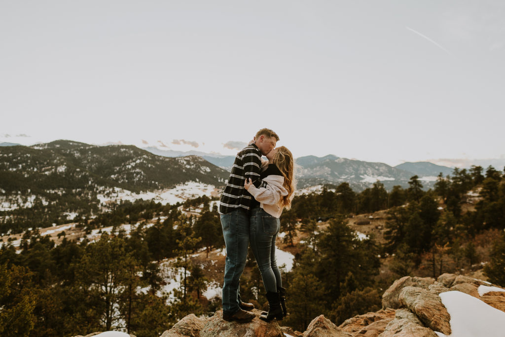 colorado engaged couple standing in front of mountains