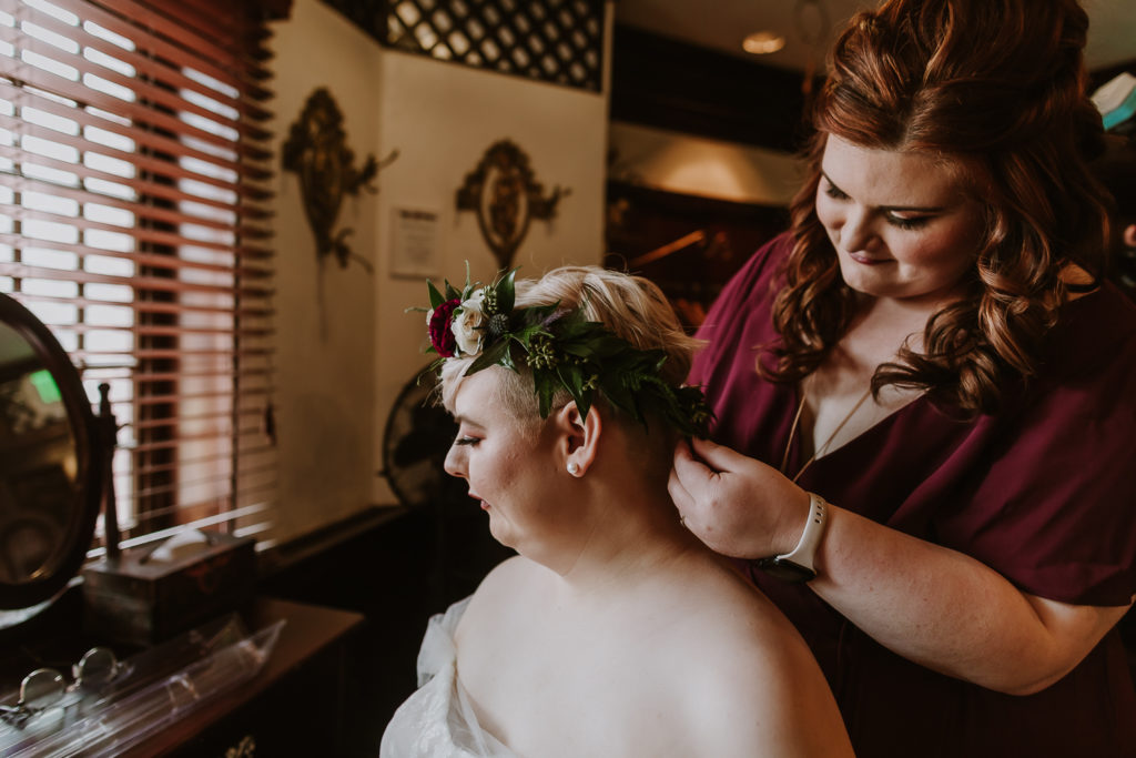 bride putting on floral crown