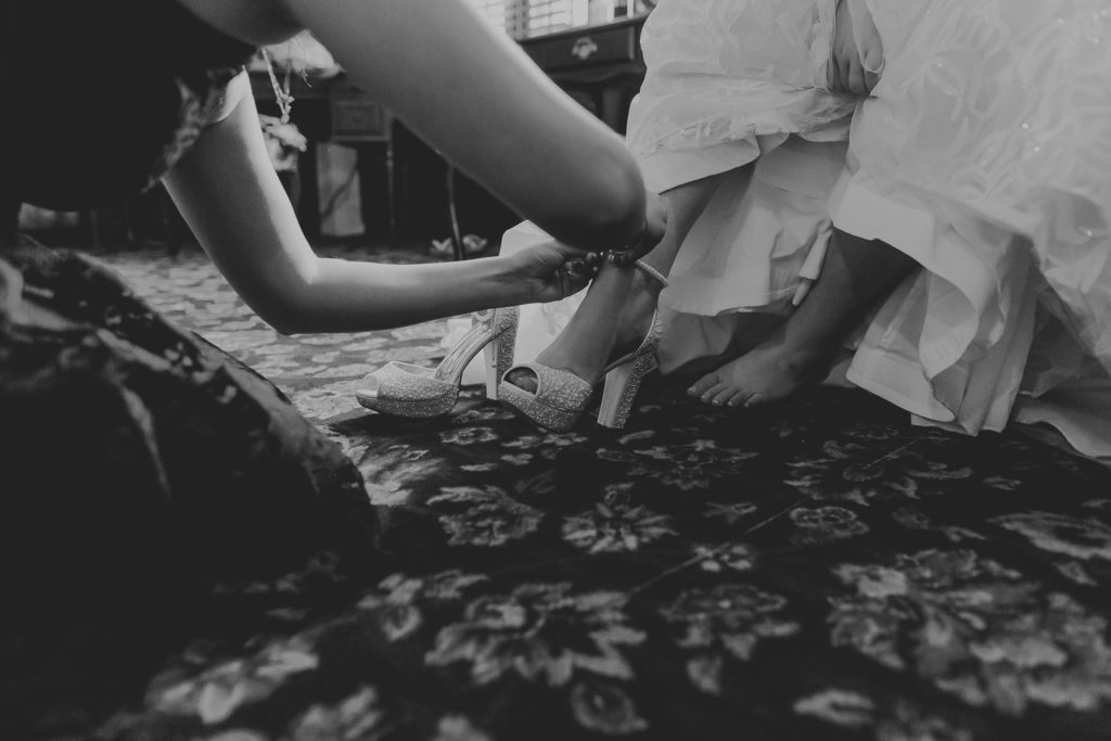 putting on bride's shoes